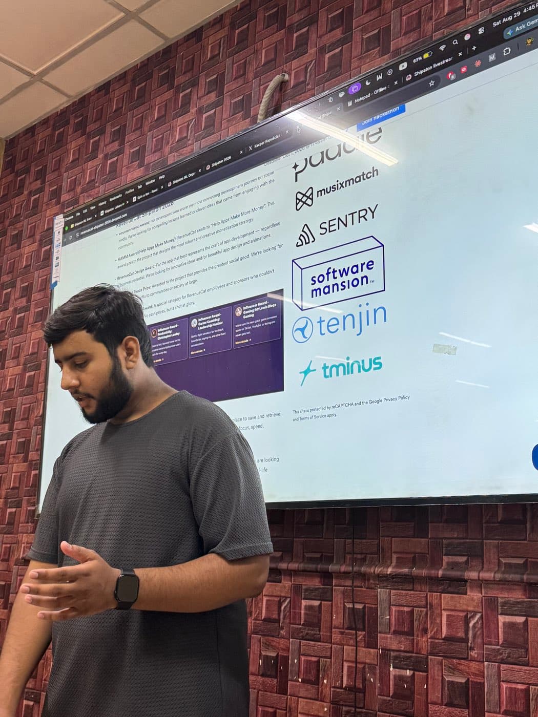 Junaid speaking in front of a projected RevenueCat Shipaton sponsor page listing Paddle, Musixmatch, Sentry, Software Mansion, Tenjin and Tminus
